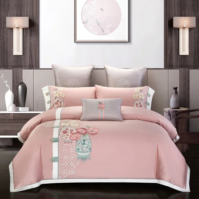 Pink and grey floral bedding set with embroidered patterns on a modern bed