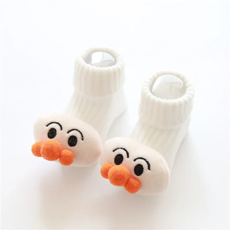 White ribbed baby socks with plush cartoon faces and orange pom-pom noses, soft material