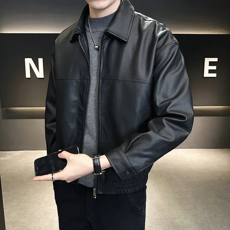 Men's black faux leather jacket, relaxed fit, collared, over gray sweater, streetwear style