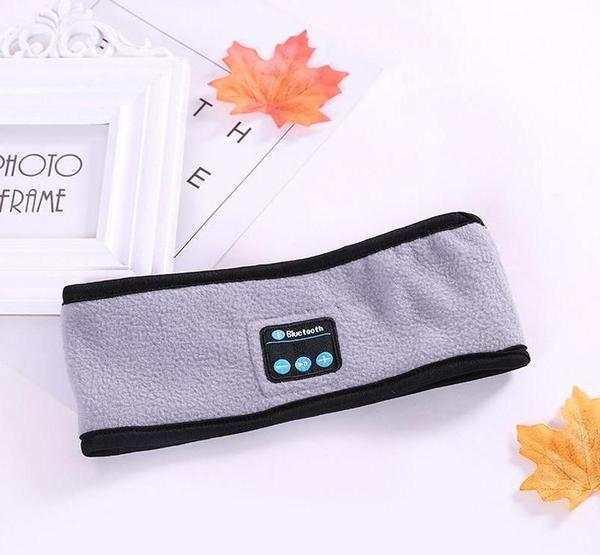 Grey fleece Bluetooth headband with black trim, soft material, tech accessory, laid flat