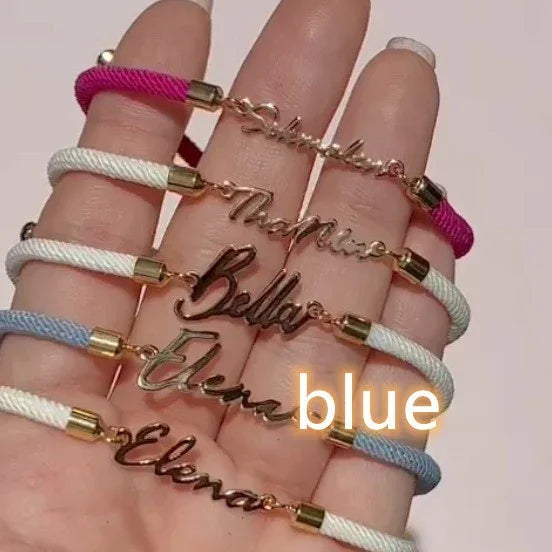 Personalized rope bracelets in pink, white, and blue with gold nameplates, casual fit