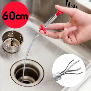 Flexible metal drain clog remover tool with red handle being used in a kitchen sink.