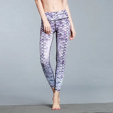 Woman wearing high-waisted, purple scale-print leggings, slim fit, stretchy fabric