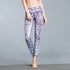 Woman wearing high-waisted, purple scale-print leggings, slim fit, stretchy fabric