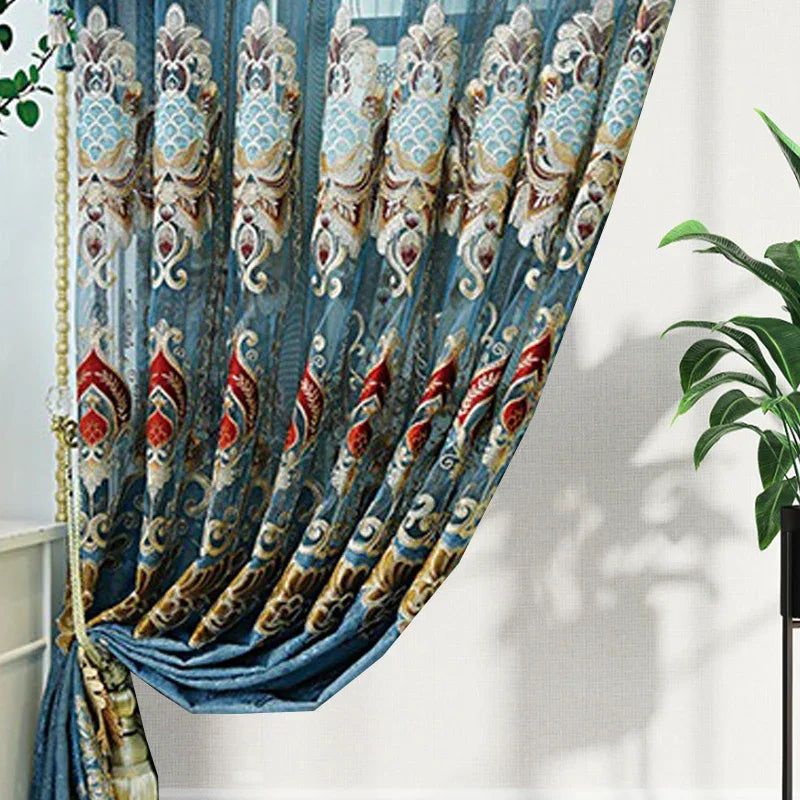 Sheer blue curtain with ornate embroidered floral patterns and luxurious drape