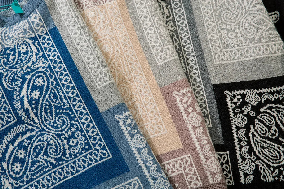 Close-up of knit sweaters in blue, beige, gray, and black with paisley and geometric patterns.