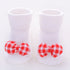 White ribbed baby socks with red and white checkered bow accents, soft cotton material