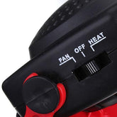 Close-up of a black and red device with a dial for fan, off, and heat settings, plastic body.