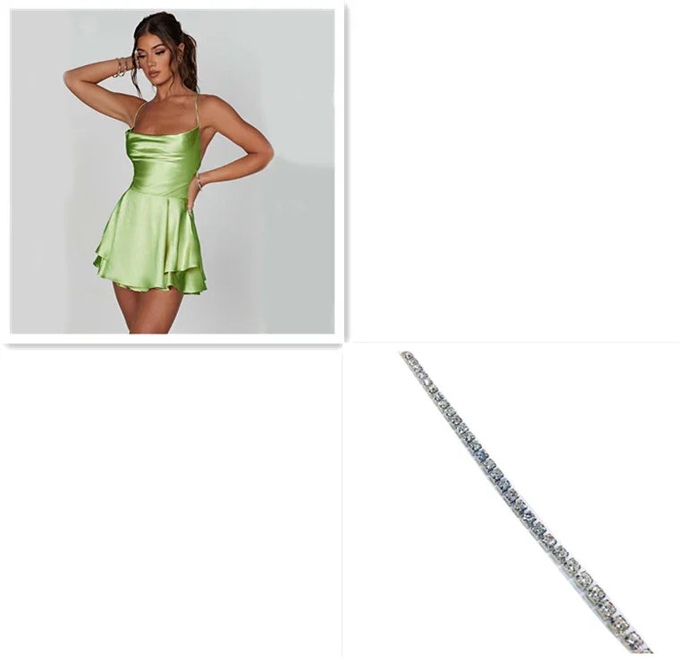 Woman in light green satin mini dress with flared skirt and thin straps, paired with a silver rhinestone bracelet.