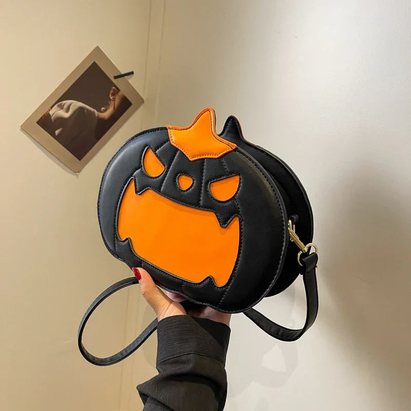 Black faux leather crossbody bag with orange pumpkin face design, playful streetwear accessory