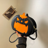 Black faux leather crossbody bag with orange pumpkin face design, playful streetwear accessory