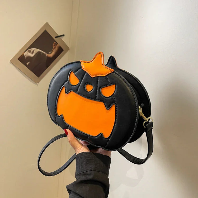 Black faux leather crossbody bag with orange pumpkin face design, playful streetwear accessory