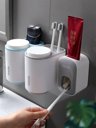 Wall-mounted toothbrush holder with dispenser, two toothbrushes, toothpaste, and storage cups