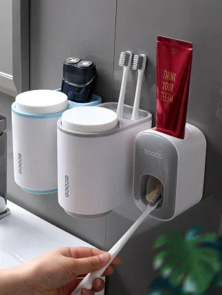 Wall-mounted toothbrush holder with dispenser, two toothbrushes, toothpaste, and storage cups