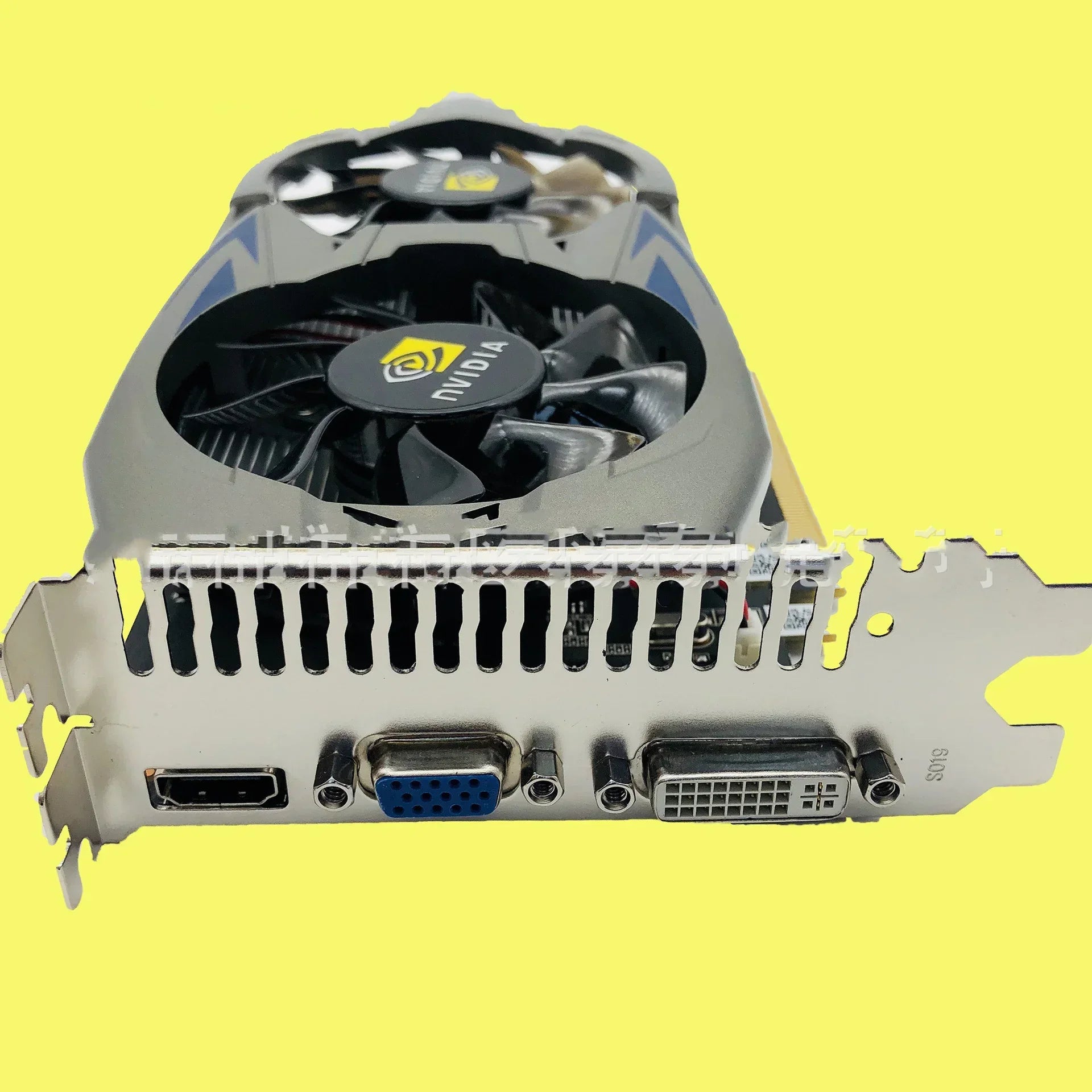 Black and silver graphics card with dual fans, HDMI, VGA, and DVI ports on yellow background.