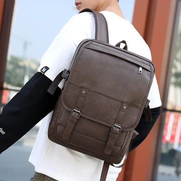 Man wearing slim-fit white and black long sleeve top with brown leather backpack