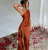 Woman wearing a satin one-shoulder rust brown dress with high slit, fitted style