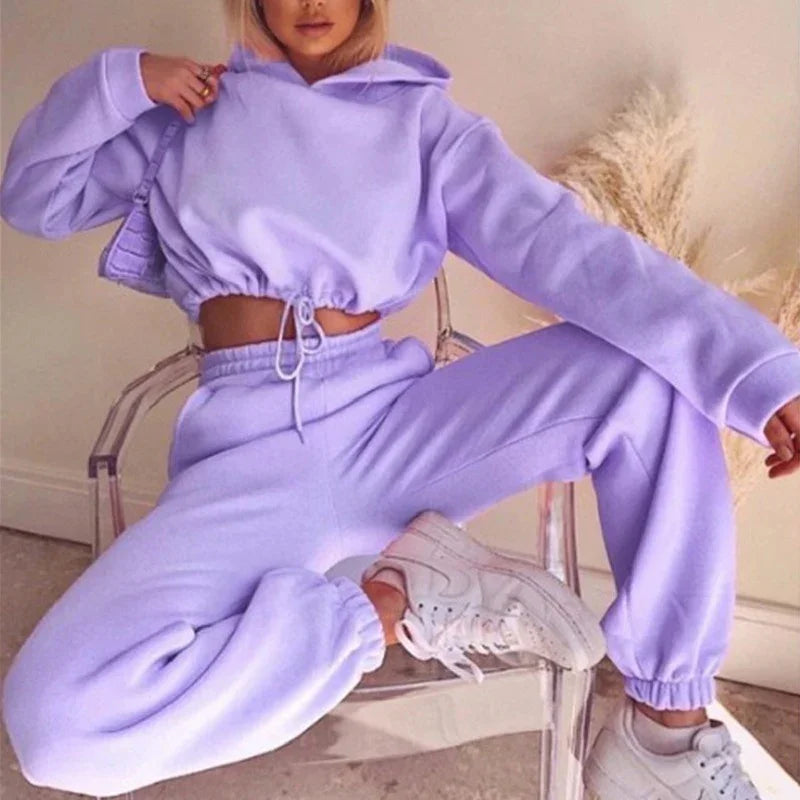Woman wearing a light purple fleece hoodie and jogger set, relaxed fit, casual streetwear.