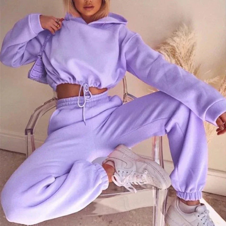 Woman wearing a light purple fleece hoodie and jogger set, relaxed fit, casual streetwear.