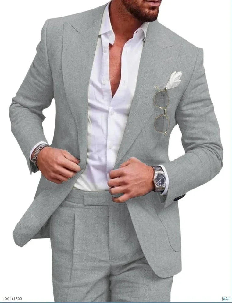 Man wearing slim fit light gray suit with white dress shirt, pocket square and metal watch