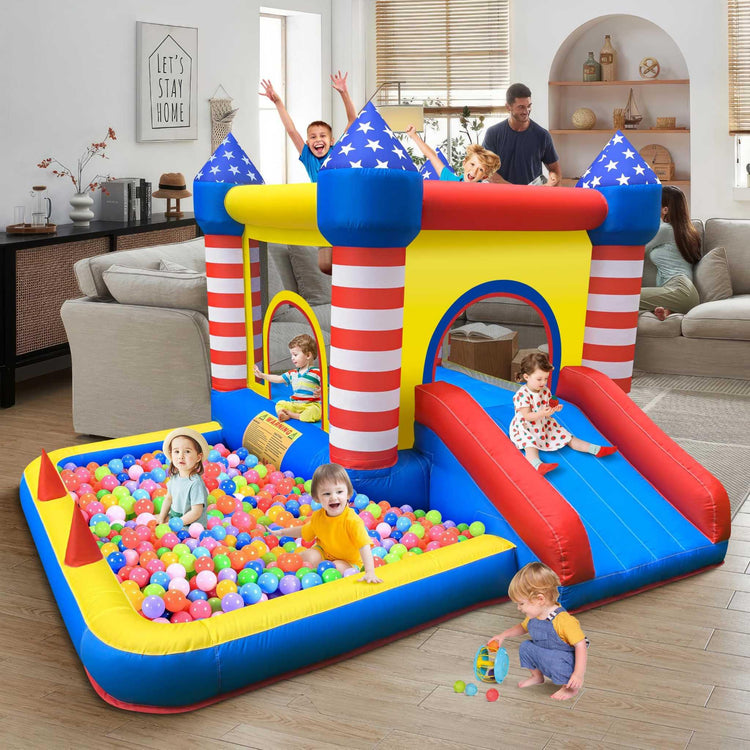 Children playing in a colorful inflatable bouncy castle with ball pit and slide indoors.