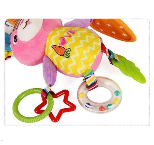 Plush pink and yellow bunny toy with textured plastic rings and colorful teether