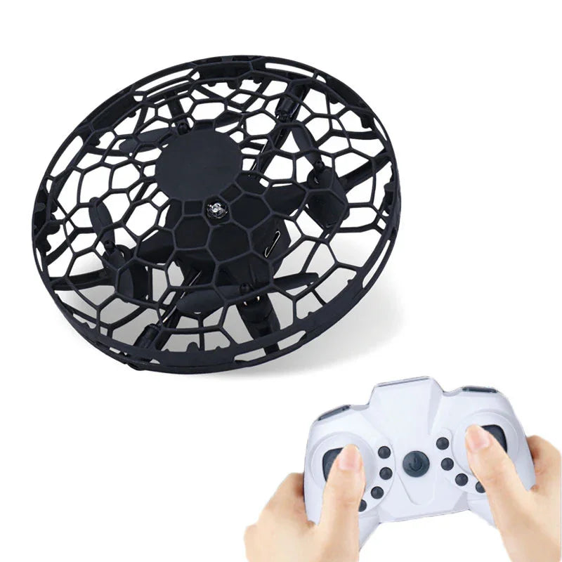 Black circular mesh mini drone with protective cage and white remote control in hands