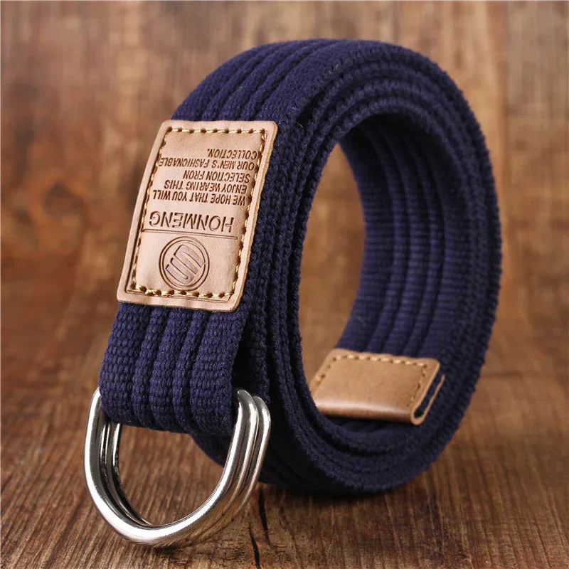 Navy blue canvas belt with double metal rings and brown leather accents on wooden surface