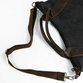 Black canvas shoulder bag with brown leather trim and adjustable strap, modern streetwear style