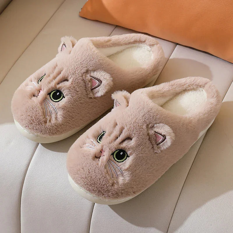 Beige plush slippers with cute cat face embroidery, cozy indoor slip-on style.