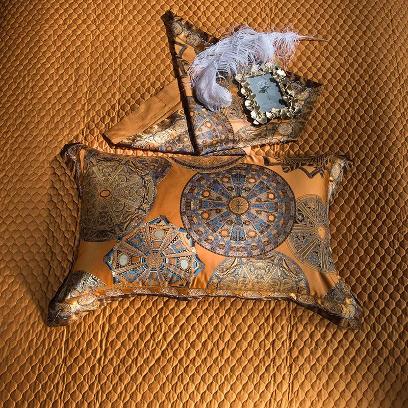 Gold and blue silk pillow with intricate geometric patterns on a quilted gold bedspread