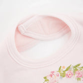 Light pink cotton t-shirt with floral print detail and soft round neckline, close-up view