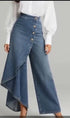 Asymmetrical high-waisted denim pants with side buttons, wide leg, and draped skirt overlay