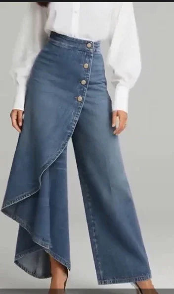 Asymmetrical high-waisted denim pants with side buttons, wide leg, and draped skirt overlay