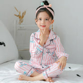 Girl in pink and white striped long-sleeve pajama set with bunny print, relaxed fit cotton sleepwear
