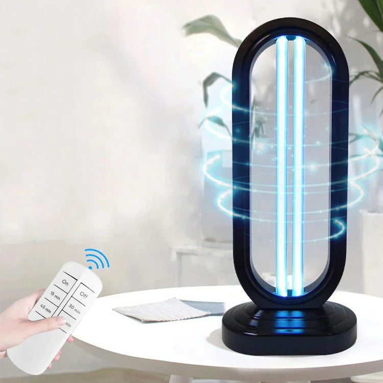 Modern UV sterilization lamp with black oval frame, blue light, and remote control on white table