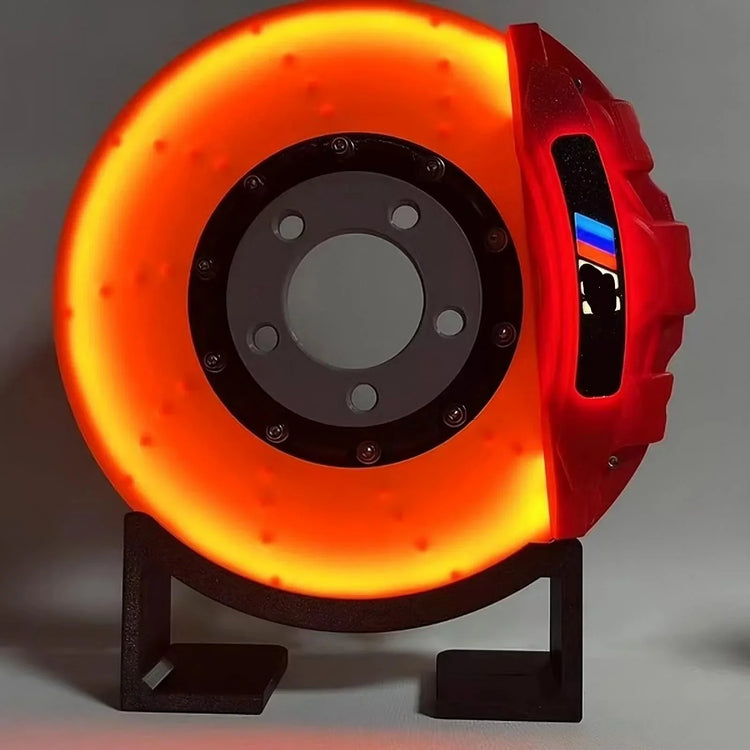 Futuristic red and orange LED brake disc lamp on stand with tech-inspired design