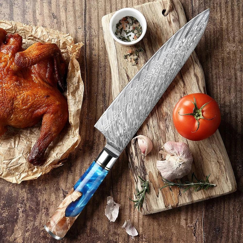 Damascus chef knife with blue resin handle on wooden board, beside tomato, garlic, and roast chicken