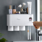Wall-mounted white bathroom organizer with cup holders and automatic toothpaste dispenser