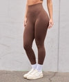 Brown high-waisted leggings with ribbed waistband, slim fit, stretchy material, paired with white sneakers