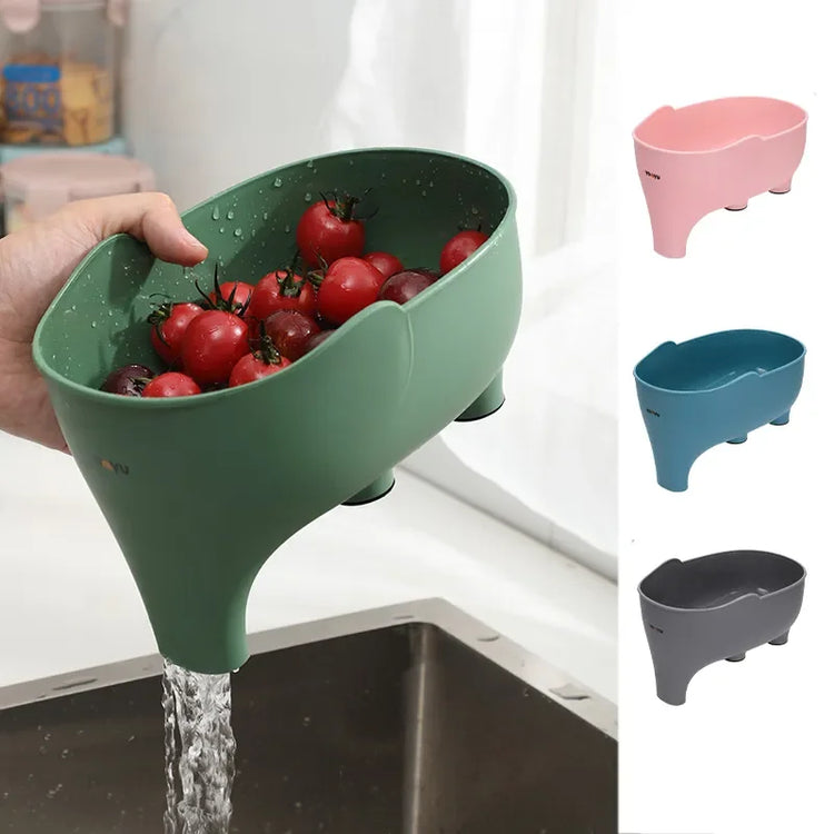 Modern plastic vegetable colander in green, pink, blue, and gray, used for rinsing produce.