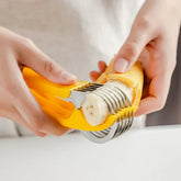 Hands using a yellow stainless steel banana slicer to cut banana into even slices