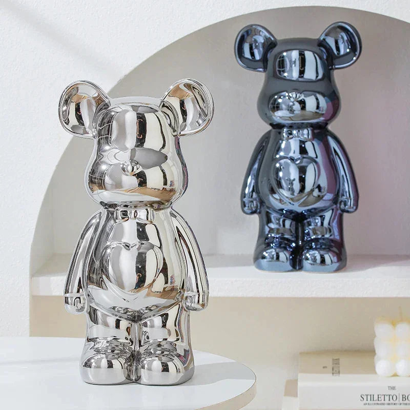 Metallic bear figurines in chrome silver and dark blue, reflective surface, modern decor