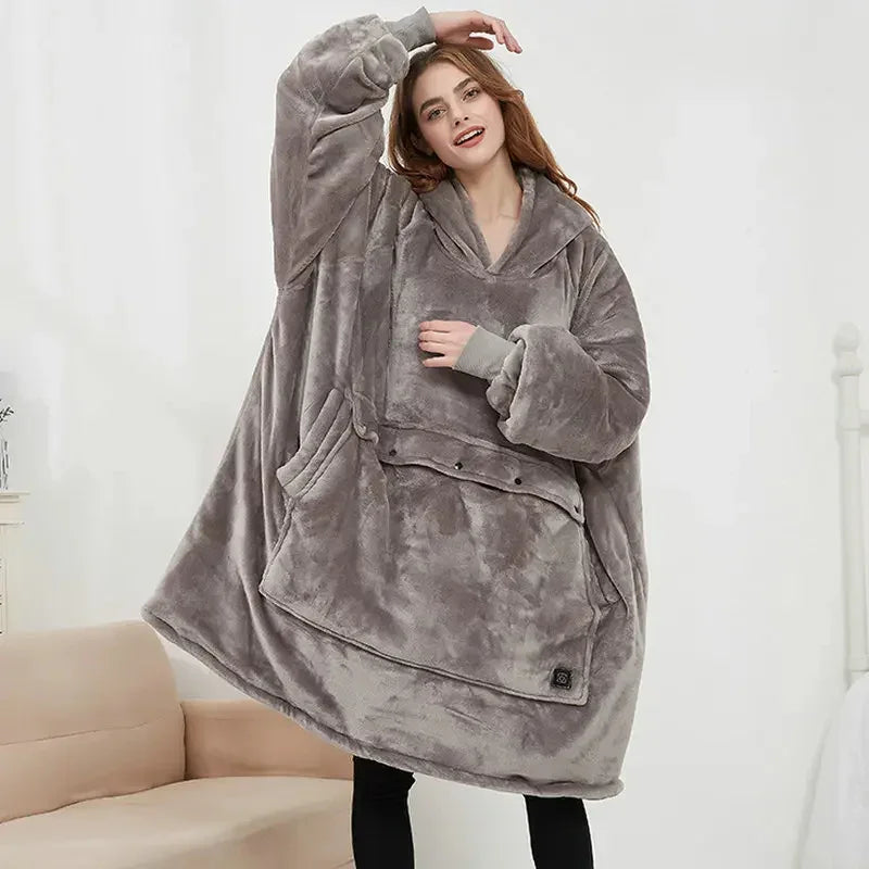 Woman wearing oversized grey fleece hoodie blanket with front pocket and relaxed fit