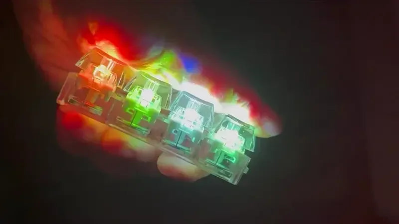 Hand holding transparent mechanical keyboard switches with colorful LED lights, tech accessory