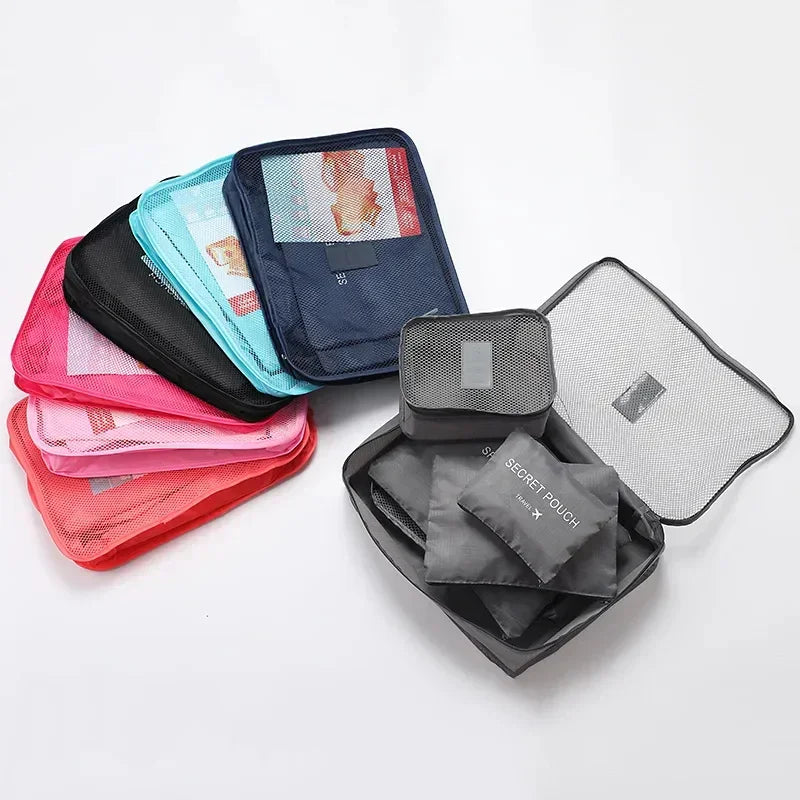 Assorted mesh travel packing cubes in blue, black, pink, and red nylon, various sizes.