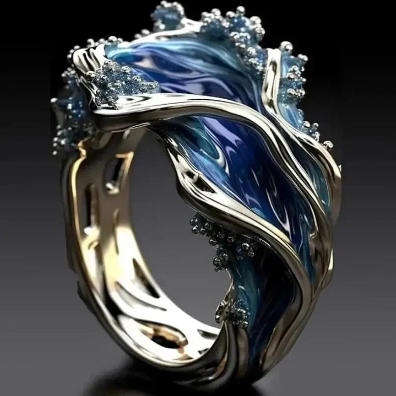 Modern silver and blue ring with wave-inspired design and gemstone accents, glossy finish
