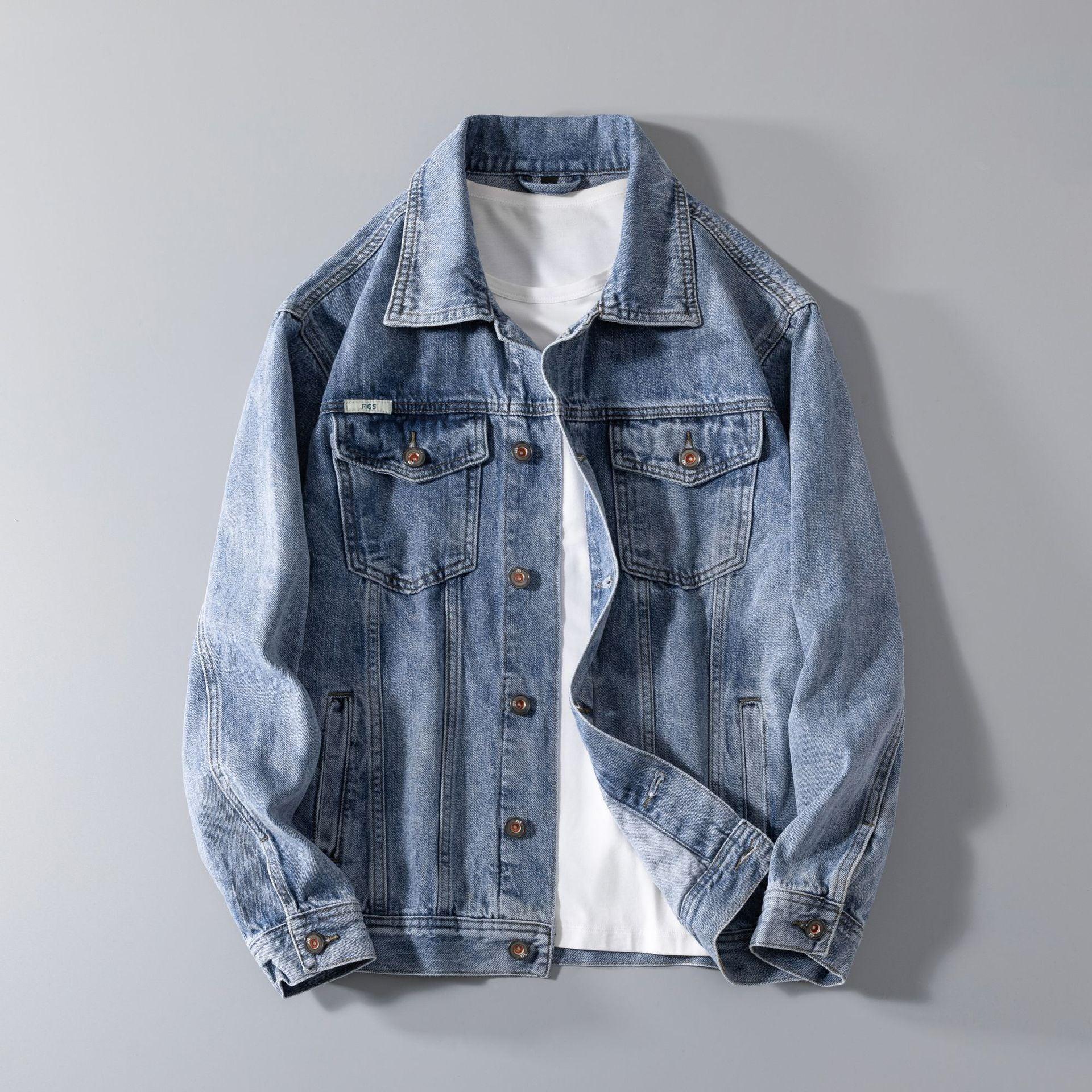 Light blue denim jacket with button front, classic collar, and relaxed fit layered over white shirt