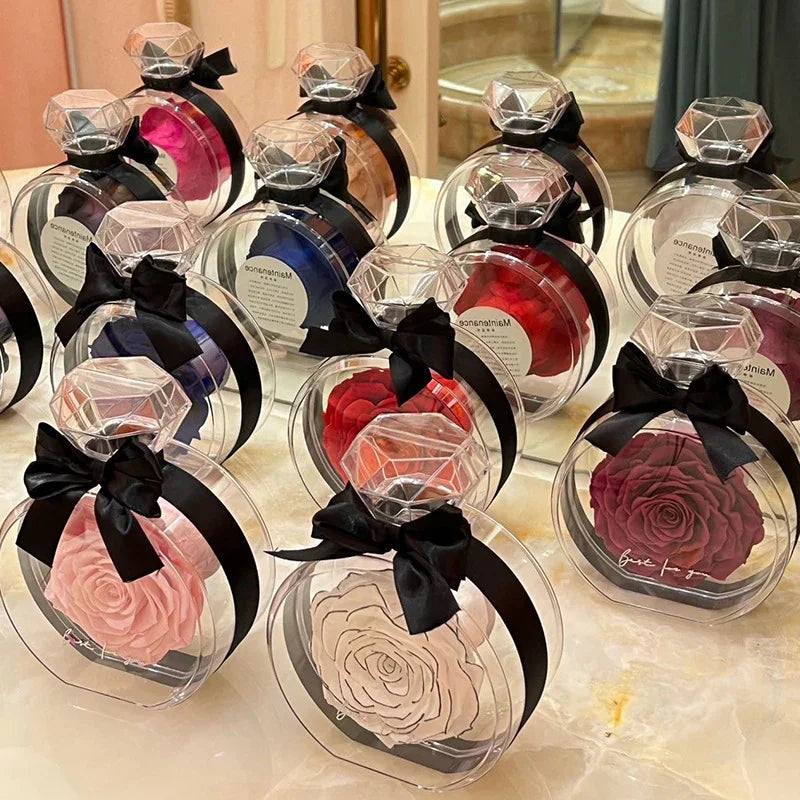 Assorted preserved roses in round clear gift boxes with black ribbon and diamond-shaped lids