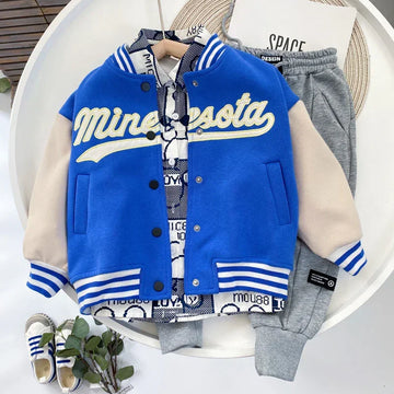 Blue and beige varsity jacket with Minnesota lettering, paired with grey jogger pants and casual sneakers.